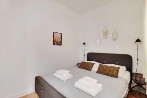 a bedroom with a bed with two towels on it at Beautiful apartment - Arc de Triomphe in Paris