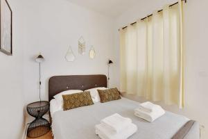 a white bedroom with a bed with towels on it at Beautiful apartment - Arc de Triomphe in Paris