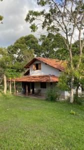 a house with an open window in a field at Chalés paradise - Família in Serra do Cipo