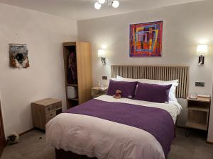 a bedroom with a large bed with purple pillows at Ceol na Mara Guest House in Tarbert
