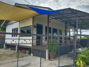 an rv with awning on a porch with a fence at Rods Homestay - Kg Agong Penaga in Kepala Batas