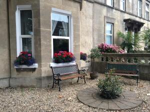 a bench in front of a window with flowers in it at Avon Guesthouse in Bath