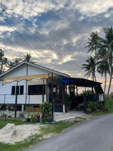 mały biały budynek z namiotem obok ulicy w obiekcie Rods Homestay - Kg Agong Penaga w mieście Kepala Batas
