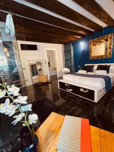 a bedroom with a king sized bed and a table at FATTORINI HOME Rooms and Suites in Chioggia in Chioggia