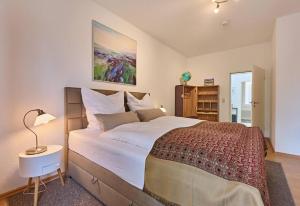 a bedroom with a large bed and a table with a lamp at Schelfstadtoase in Schwerin