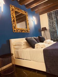 a bedroom with a bed with a mirror on the wall at FATTORINI HOME Rooms and Suites in Chioggia in Chioggia