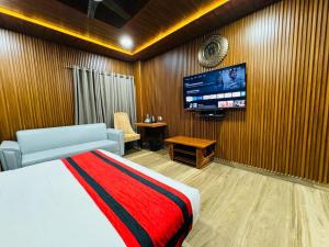um quarto com uma cama e uma televisão de ecrã plano em N.K. Residency em Guwahati