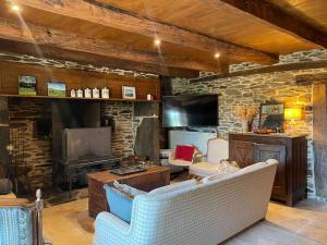 sala de estar con sofá y pared de piedra en Magnifique corps de ferme, en Montpeyroux