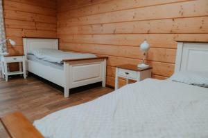 Vysoká nad KysucouにあるDrevenice Horné Kysuceのベッド2台 木製の壁の部屋