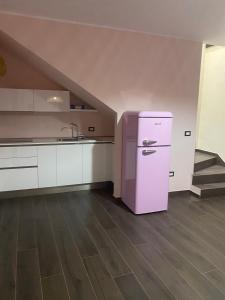 een keuken met een roze koelkast in een kamer bij Residence La Torre in Acerenza
