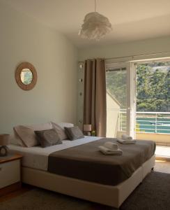 ein Schlafzimmer mit einem großen Bett und einem großen Fenster in der Unterkunft Villa Casia in Mokošica