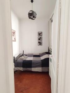 ein Schlafzimmer mit einem schwarz-weißen Bett in einem Zimmer in der Unterkunft Appartement typique entre la Gare et la Canebière in Marseille
