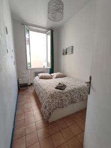 Schlafzimmer mit einem Bett und einem Fenster in der Unterkunft Appartement typique entre la Gare et la Canebière in Marseille