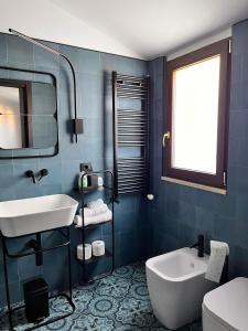 La salle de bains bleue est pourvue d'un lavabo et de toilettes. dans l'établissement Residence La Torre, à Acerenza