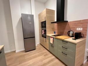 a kitchen with a stainless steel refrigerator and cabinets at Mestalla Garden in Valencia