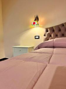 a bedroom with a pink bed with a light above it at Residence La Torre in Acerenza