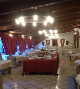 un comedor con mesas y sillas blancas y mantel rojo en Agriturismo Le Francesche, en Nocera Umbra