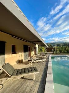 una casa con piscina y tumbonas en una terraza en Maison de campagne entre Ajaccio et Porticcio, en Cauro