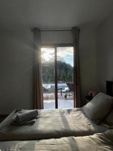 Schlafzimmer mit einem Bett und einem Fenster mit Aussicht in der Unterkunft Maison de campagne entre Ajaccio et Porticcio in Cauro