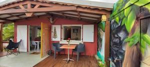ein Haus mit einem Tisch und Stühlen auf einer Terrasse in der Unterkunft Villa d'une chambre avec piscine privee terrasse amenagee et wifi a Petit Bourg in Petit-Bourg