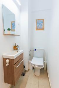 La salle de bains est pourvue de toilettes blanches et d'un lavabo. dans l'établissement Ultracentral Dreamland Apartment 3 Bdrm, à Bucarest