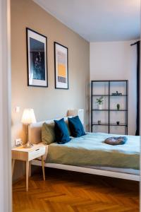 a bedroom with a bed with blue pillows and a table at Ultracentral Dreamland Apartment 3 Bdrm in Bucharest