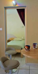 1 dormitorio con espejo, cama y mesa en F 1 COCOON au coeur de Prades en Prades