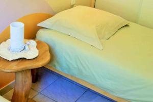Una cama pequeña con una mesa junto a una almohada en F 1 COCOON au coeur de Prades en Prades