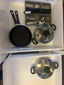 a cabinet with pots and pans and utensils at New Stylish 2-Bed Retreat in Central Windsor in Windsor