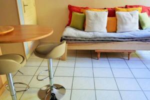 un sofá con almohadas coloridas y una mesa en F 1 COCOON au coeur de Prades en Prades