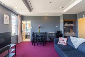a living room with a couch and a table with chairs at Urban Nest, 1-BDRM Apt in Halifax