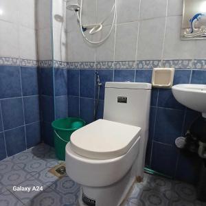 een badkamer met een wit toilet en een wastafel bij Nevada Place in Baguio