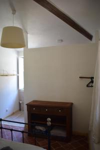 - une chambre avec une commode en bois et une lampe dans l'établissement Mas du Pont, à Saint-Jean-de-Maruéjols-et-Avéjan