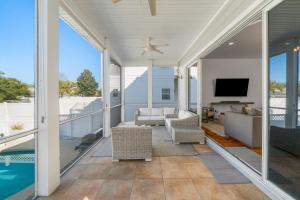 a screened in porch with a pool and a tv at Destin Beach House - Gulf Moon by Panhandle Getaways in Destin