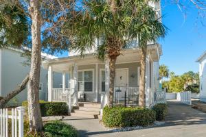 a white house with palm trees in front of it at Destin Beach House - Gulf Moon by Panhandle Getaways in Destin