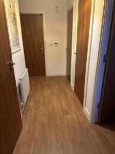 an empty hallway with two doors and a hard wood floor at Beautiful East London Flat in Barking