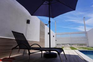 uma cadeira com um guarda-chuva ao lado de uma piscina em ESTRELA DO MAR em Prado