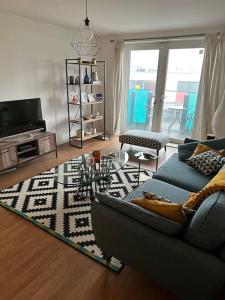 a living room with a couch and a table at Beautiful East London Flat in Barking