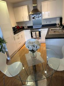 a kitchen with a vase of flowers on a table at Beautiful East London Flat in Barking