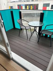 a balcony with a table and chairs on a balcony at Beautiful East London Flat in Barking