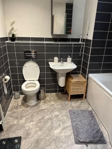 a bathroom with a toilet and a sink at Beautiful East London Flat in Barking