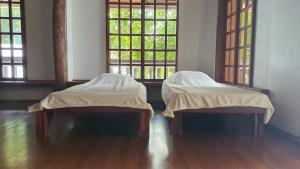 two beds sitting in a room with two windows at Feelgood Whitesand Resort in Lapu Lapu City