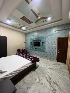 1 dormitorio con 1 cama y TV en la pared en Shri Ram Gopal Residency, en Faizābād