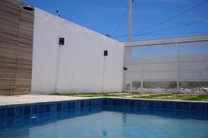 a swimming pool in front of a white building at ESTRELA DO MAR in Prado