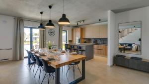 a dining room and kitchen with a long table and chairs at Villa Amoroso by Villas Holiday in Nova Vas
