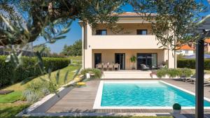 a villa with a swimming pool in front of a house at Villa Amoroso by Villas Holiday in Nova Vas