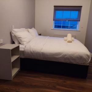 a bedroom with a bed with white sheets and a window at Parliament Inn in Kilkenny