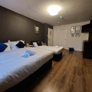 a hotel room with two beds and wooden floors at Parliament Inn in Kilkenny