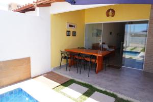 ESTRELA DO MAR في برادو: غرفة طعام ومطبخ مع طاولة وكراسي