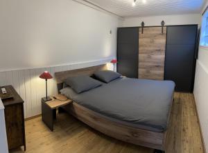 Schlafzimmer mit einem großen Bett mit einem Kopfteil aus Holz in der Unterkunft Winnys House in Dirbach